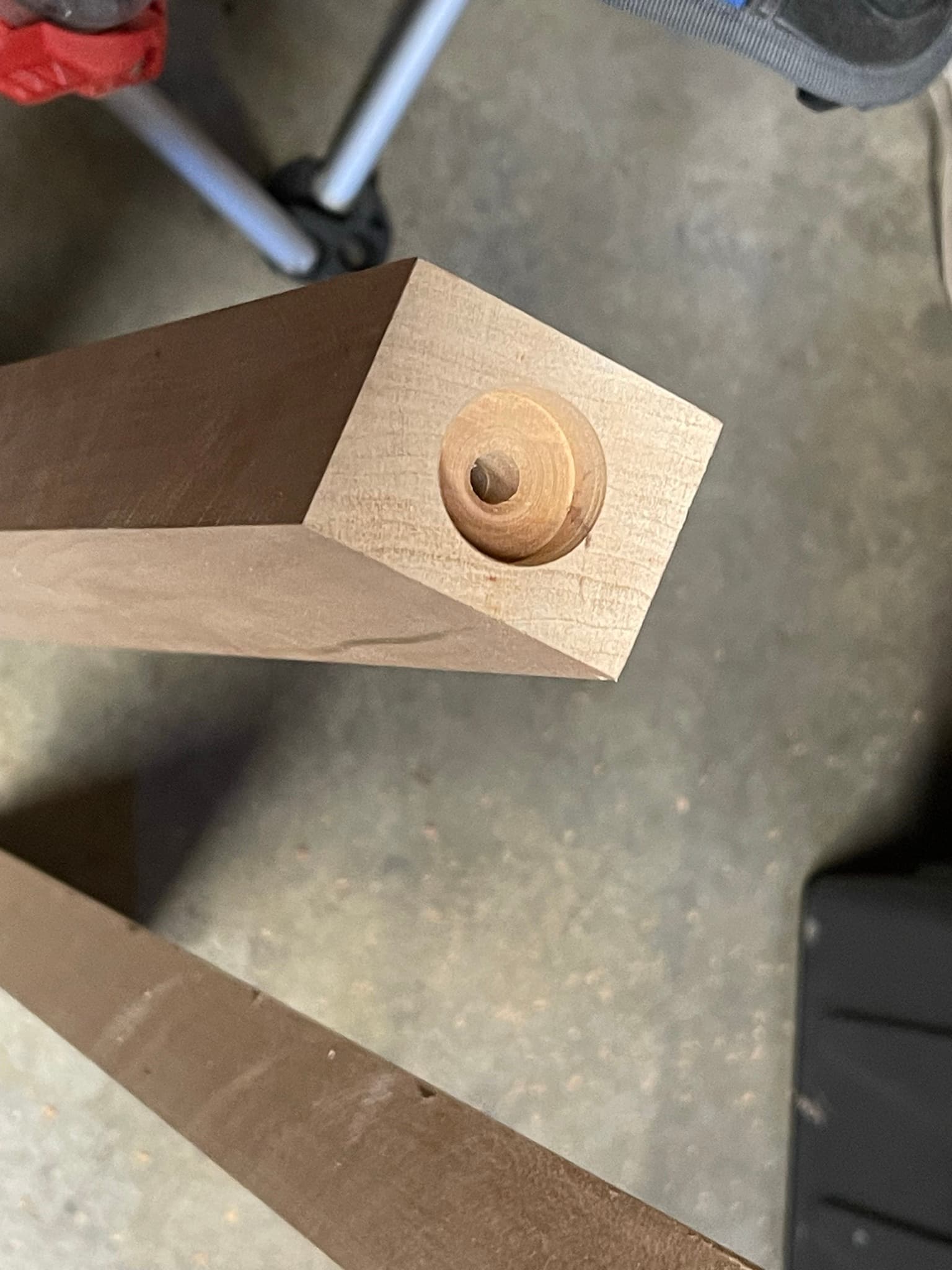 Close-up of the top of one maple leg: counterbored well with a stainless threaded insert seated inside.
